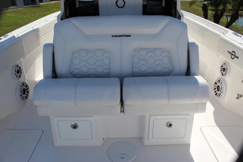 Slide: The Image of 2024 Fountain 32 NX boat interior with white cushioned seating and storage compartments. - 47