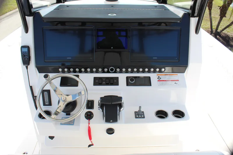 Slide: The Image of 2024 Fountain 32 NX boat dashboard with dual screens and steering wheel. - 51