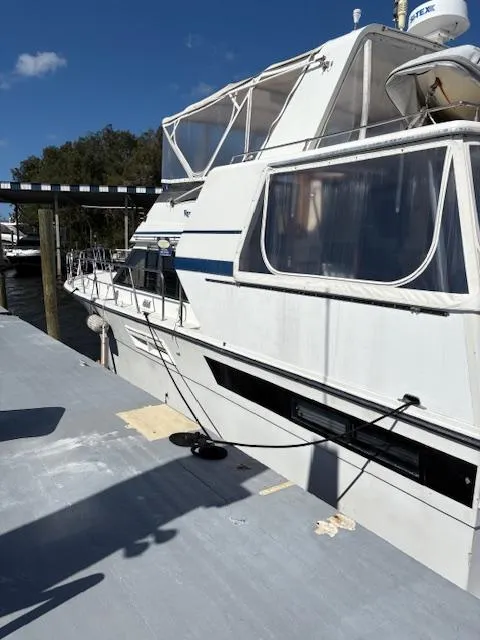 Slide: The Image of 1990 Californian 45 Motor Yacht docked, featuring white exterior and spacious cabin. - 12