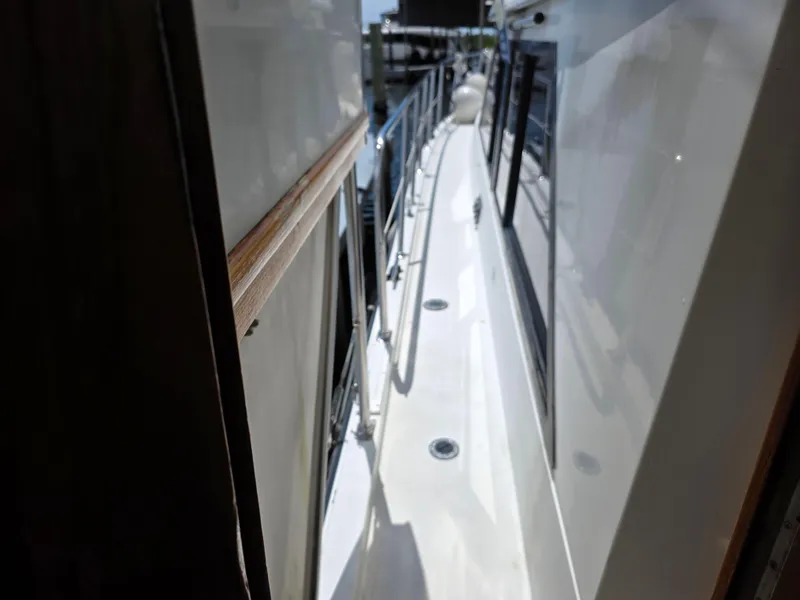 Slide: The Image of Side deck view of a 1990 Californian 45 Motor Yacht, featuring sleek design and railings. - 17