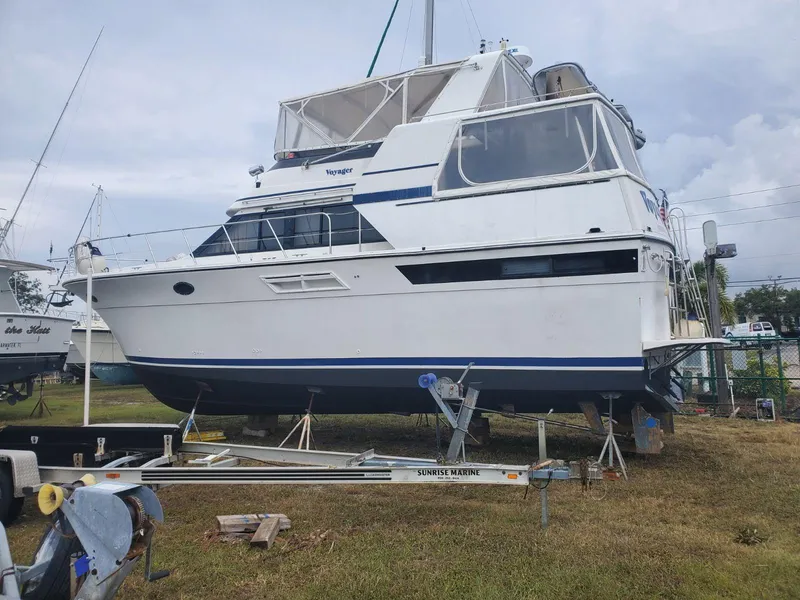 Slide: The Image of 1990 Californian 45 Motor Yacht on land, white hull, blue stripe, covered upper deck. - 2