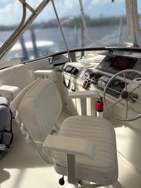 Slide: The Image of 1990 Californian 45 Motor Yacht helm with white seating and navigational controls. - 24