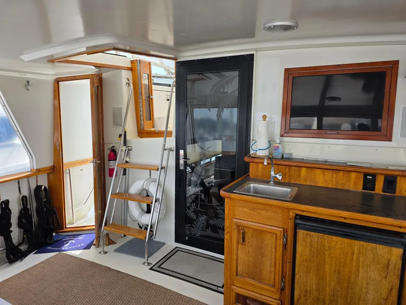 Slide: The Image of 1990 Californian 45 Motor Yacht interior with kitchenette, ladder, and door. - 25