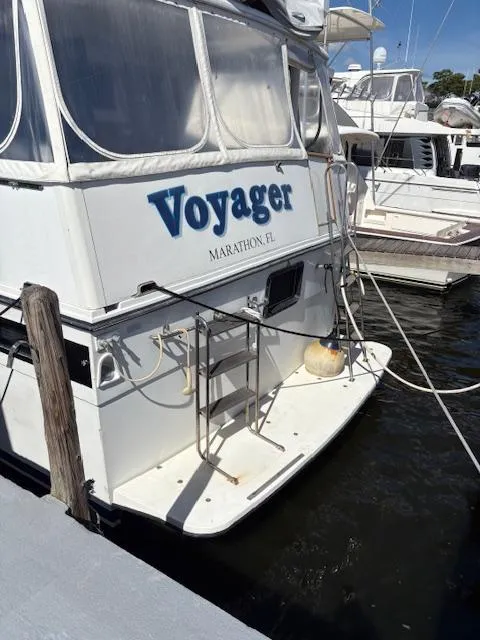 Slide: The Image of 1990 Californian 45 Motor Yacht "Voyager" docked at marina, featuring rear deck and ladder. - 9