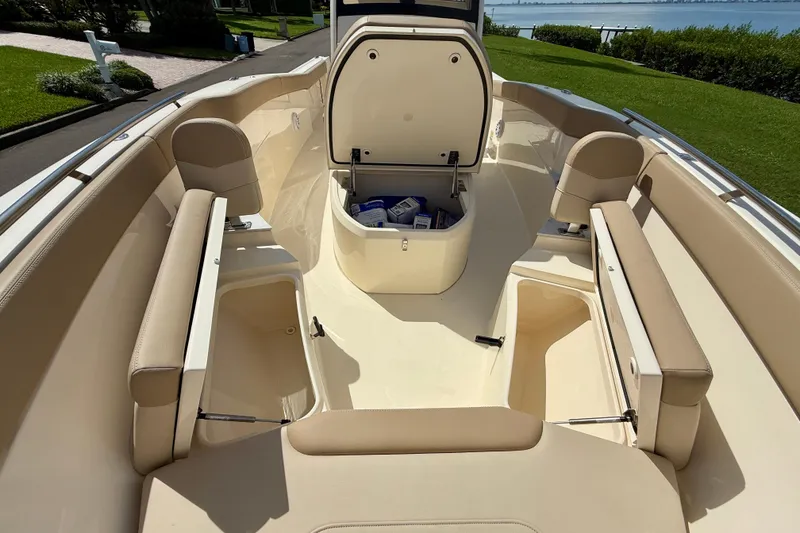 Slide: The Image of 2025 Scout 240 XSF boat interior with beige seating and storage compartments. - 20