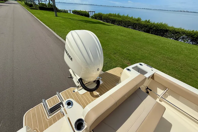 Slide: The Image of 2025 Scout 240 XSF boat with Yamaha engine, parked by a scenic waterfront. - 6