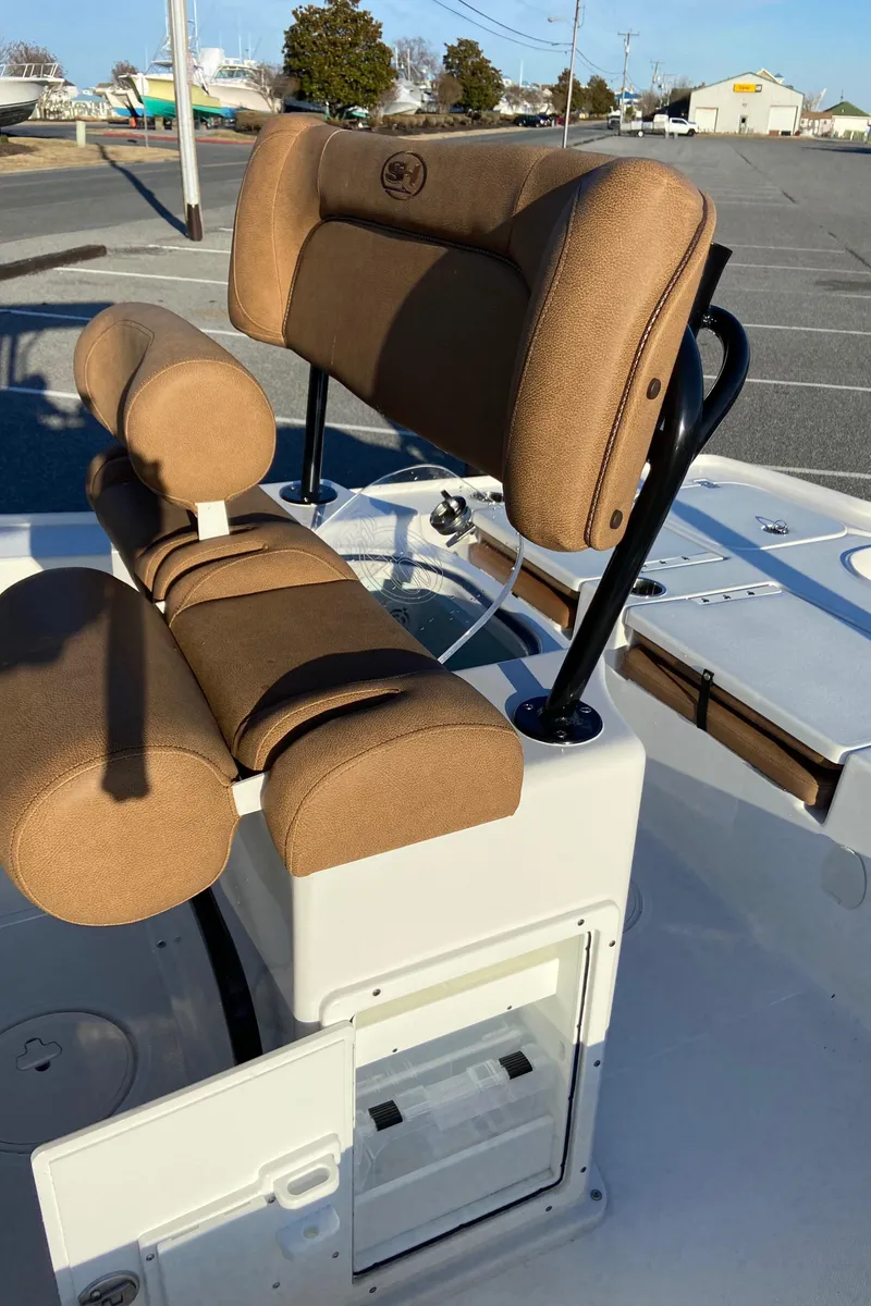Slide: The Image of 2021 Sea Hunt BX 22 BR boat seating with tan cushions and storage compartment. - 14