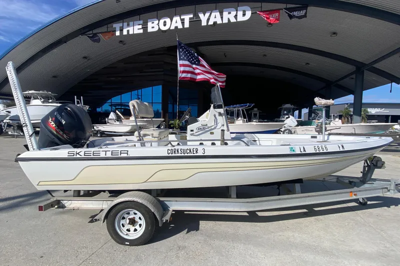 Slide: The Image of 2005 Skeeter ZX20 Bay boat, white interior, docked outdoors under clear blue sky. - 12