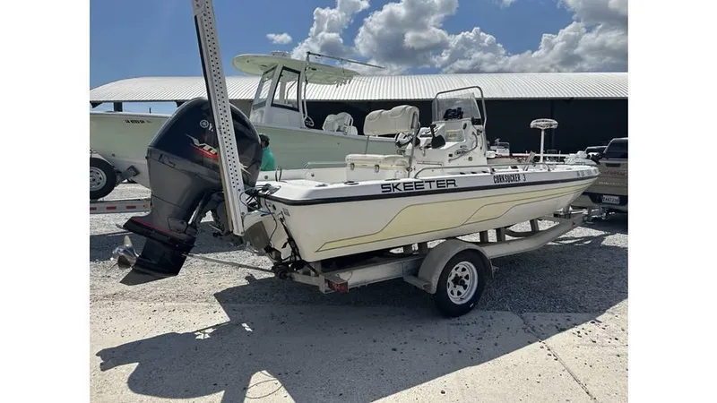 Slide: The Image of 2005 Skeeter ZX20 Bay boat on trailer, parked outdoors under clear blue sky. - 6