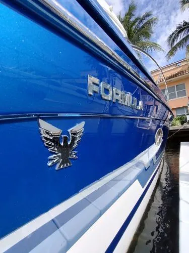 Slide: The Image of 2017 Formula 37 PC boat, blue exterior, docked with palm trees in background. - 4
