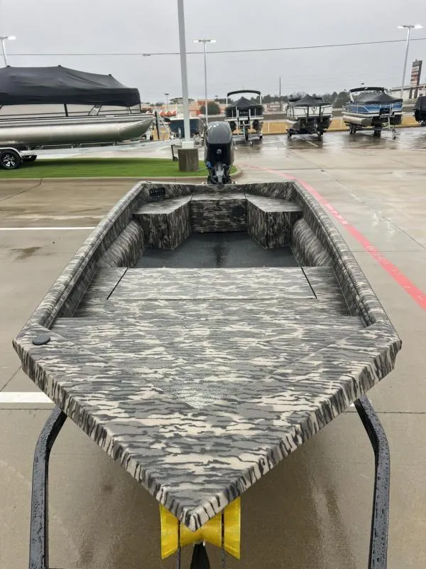 Slide: The Image of 2025 Havoc Boats 1656 VJST with camouflage design in a marina setting. - 8