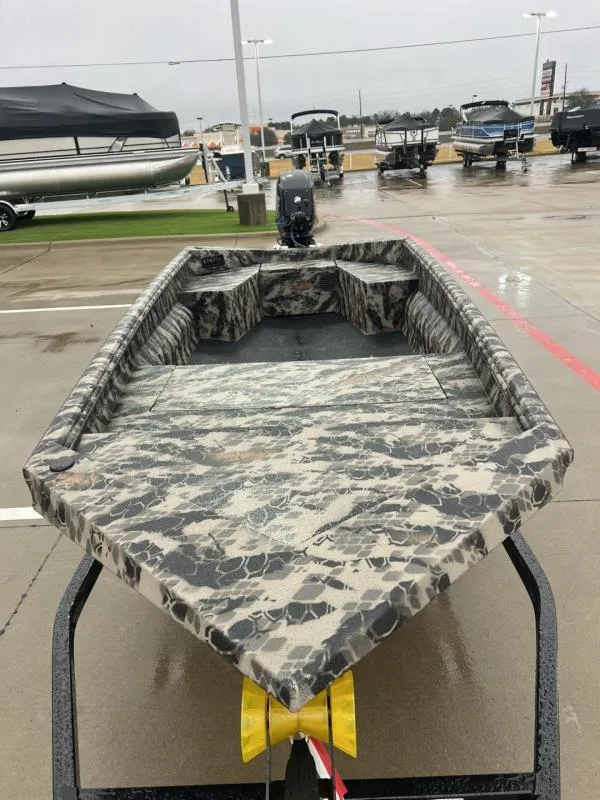 Slide: The Image of 2025 Havoc Boats 1656 VJST with camouflage design on display at a dealership. - 8