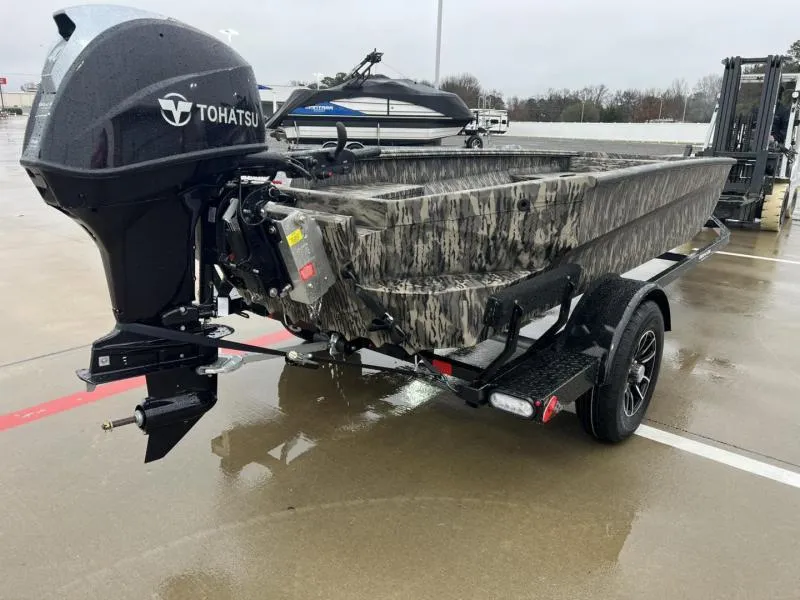 Slide: The Image of 2025 Havoc Boats 1656 VJST with Tohatsu motor on trailer, parked outdoors. - 3