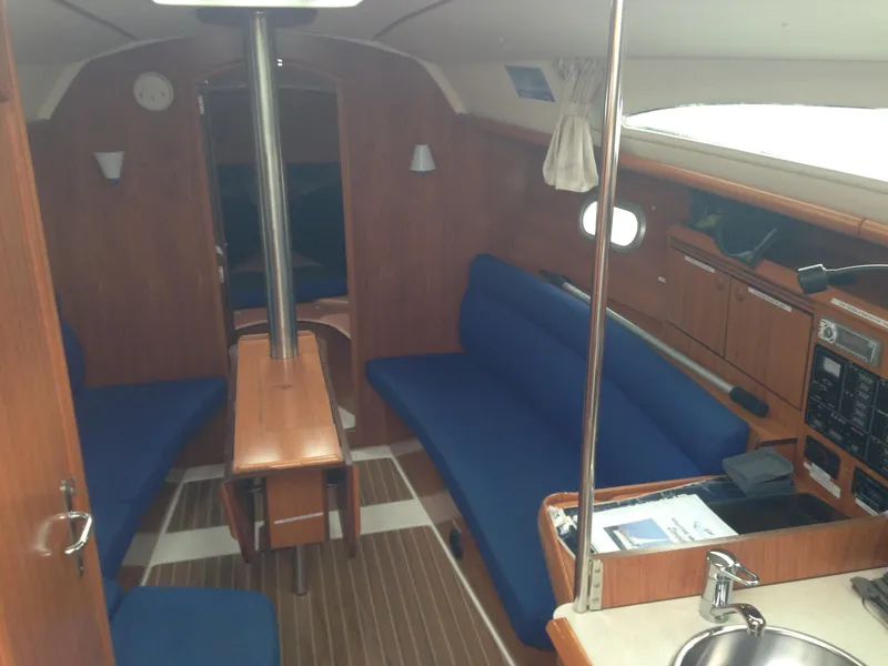 Slide: The Image of Interior of 2003 Jeanneau Sun Odyssey 32i sailboat with blue seating and wooden finishes. - 14