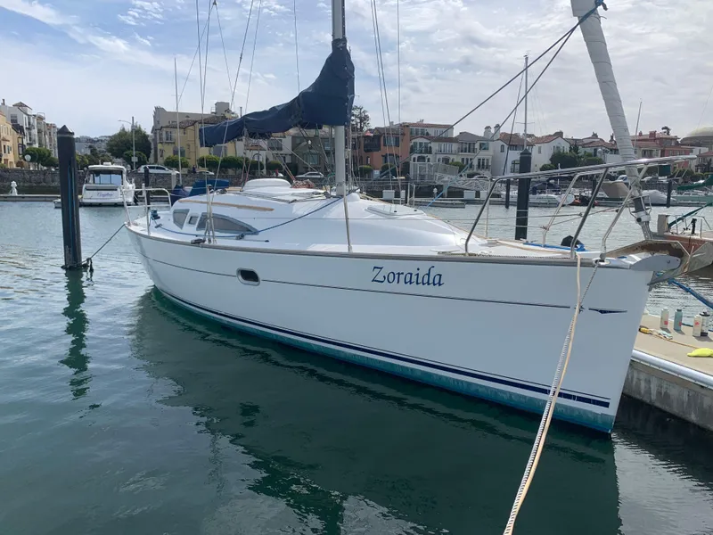 Slide: The Image of 2003 Jeanneau Sun Odyssey 32i sailboat docked in a marina, named "Zoraida." - 21