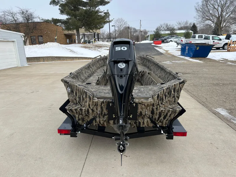 Slide: The Image of 2025 Excel 1651 River Warrior boat with camouflage design and 50 HP motor, parked outdoors. - 5