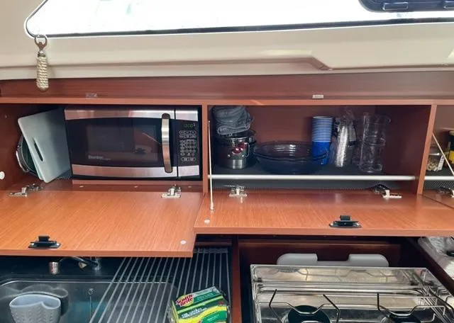 Slide: The Image of Interior view of 2018 Beneteau Oceanis 41.1 kitchen with microwave and storage cabinets. - 13