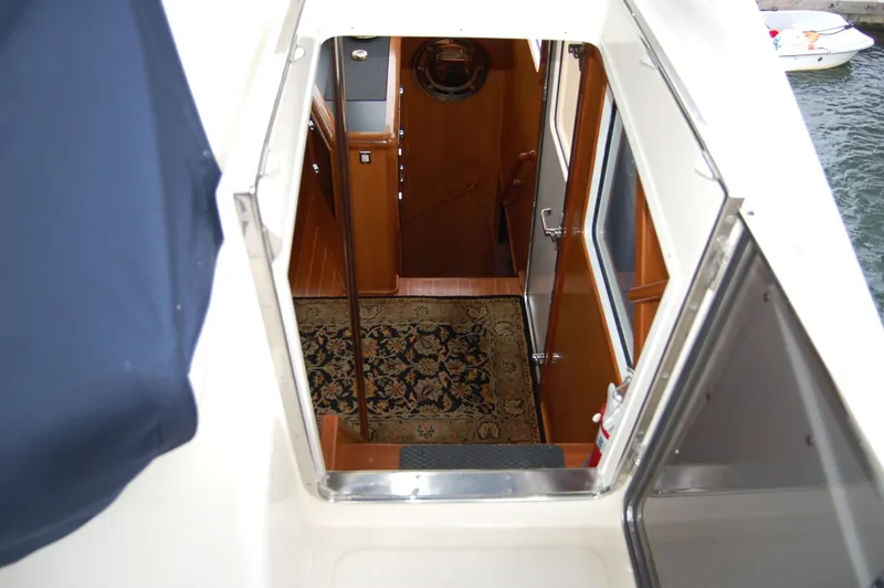 Slide: The Image of Interior view of 2002 Eagle Pilothouse boat, featuring wooden finishes and a patterned rug. - 11