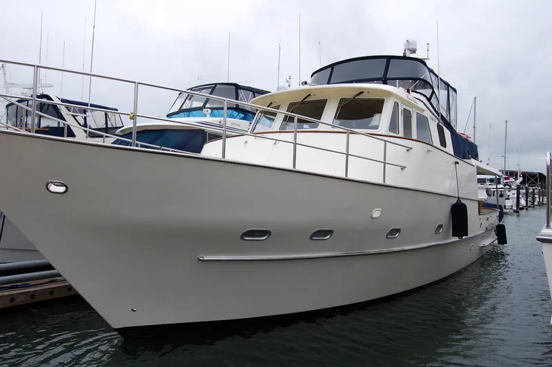 Slide: The Image of 2002 Eagle Pilothouse yacht docked in marina, showcasing sleek design and spacious deck. - 2