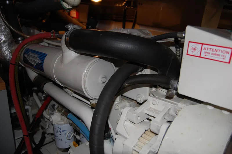 Slide: The Image of Engine compartment of a 2002 Eagle Pilothouse boat, featuring various hoses and components. - 23