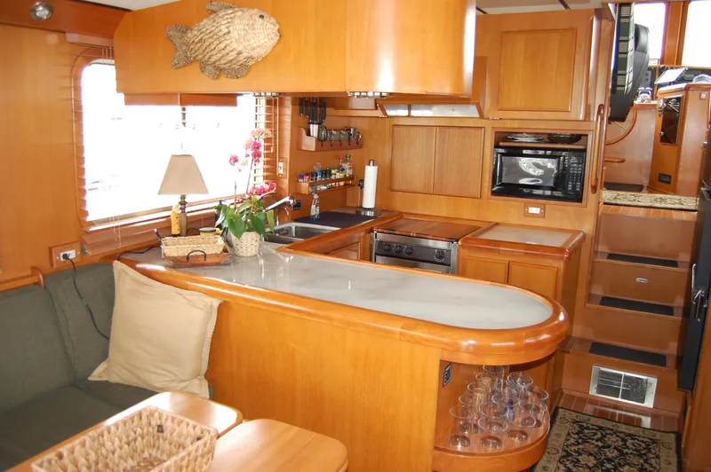 Slide: The Image of Interior of a 2002 Eagle Pilothouse yacht with wooden cabinetry and modern kitchen amenities. - 27