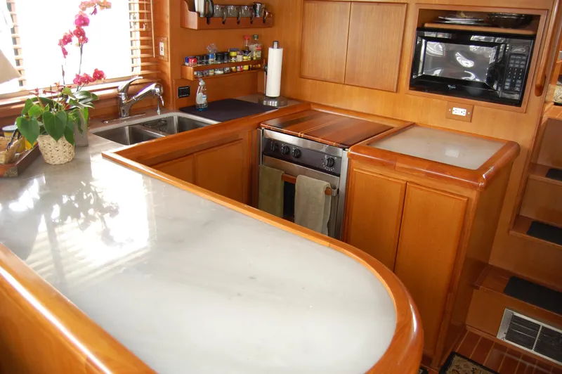 Slide: The Image of Luxurious 2002 Eagle Pilothouse kitchen with wood cabinetry, marble countertops, and modern appliances. - 28