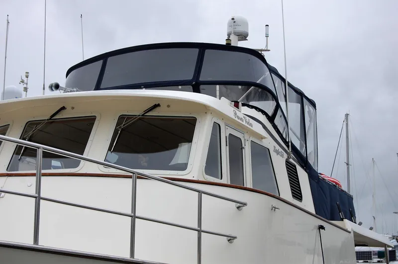 Slide: The Image of 2002 Eagle Pilothouse boat with enclosed upper deck, docked at marina. - 3