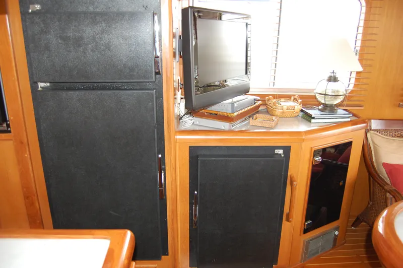 Slide: The Image of 2002 Eagle Pilothouse interior with black cabinets, TV, and wooden accents. - 36