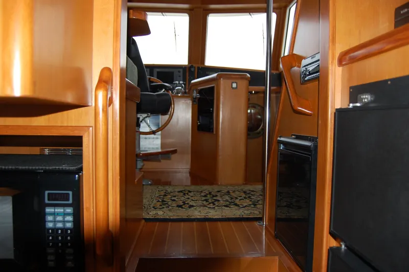 Slide: The Image of Interior of a 2002 Eagle Pilothouse boat with wooden finishes and navigation area. - 37