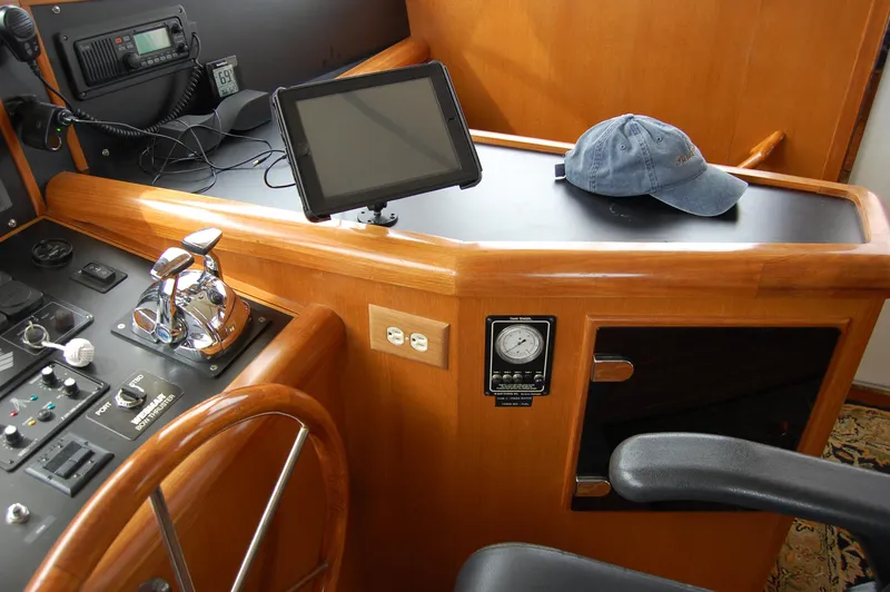 Slide: The Image of 2002 Eagle Pilothouse helm with steering wheel, controls, and navigation equipment. - 39