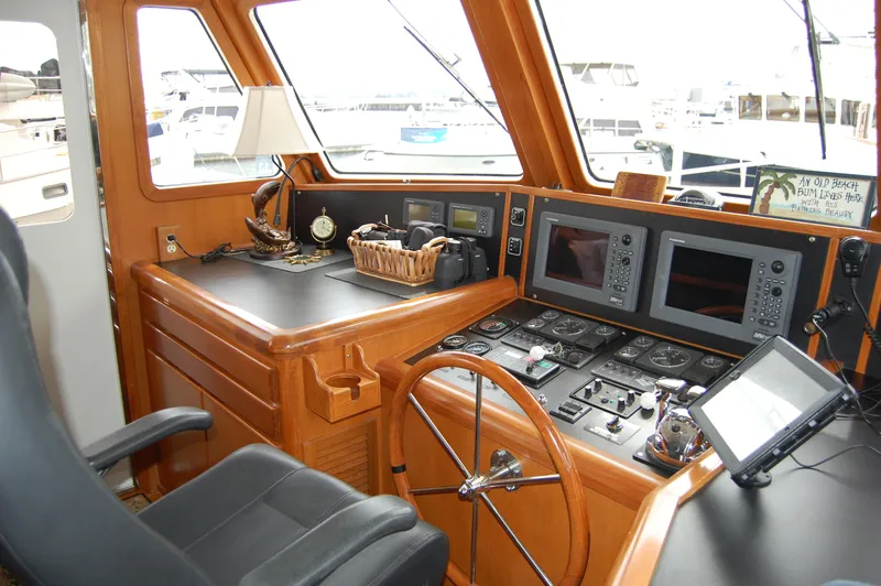Slide: The Image of Pilothouse interior of 2002 Eagle model, featuring navigation equipment and wooden steering wheel. - 40
