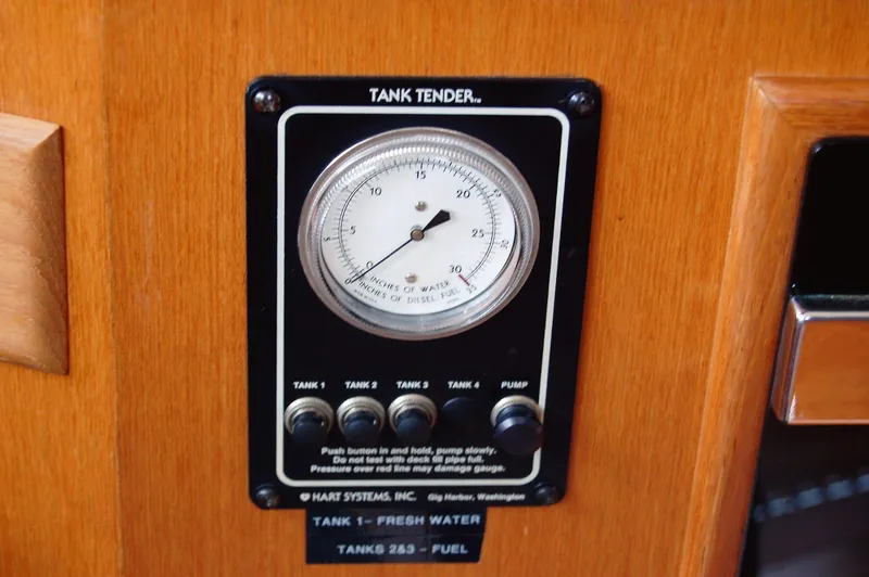 Slide: The Image of 2002 Eagle Pilothouse tank tender gauge on wooden panel, displaying water and fuel levels. - 43