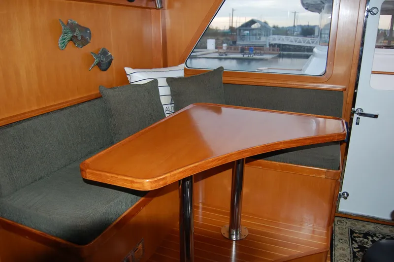 Slide: The Image of Cozy seating area in 2002 Eagle Pilothouse with wooden table and nautical decor. - 46