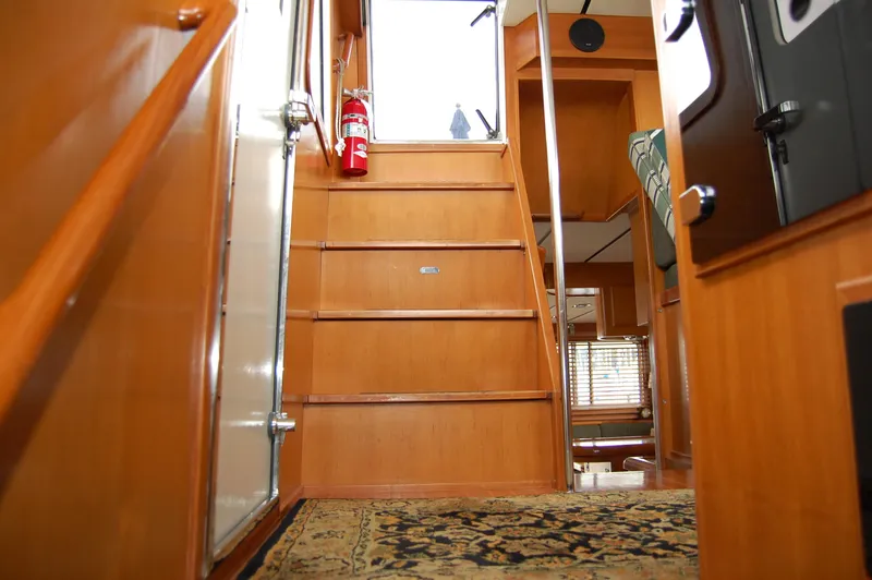 Slide: The Image of Interior view of 2002 Eagle Pilothouse, featuring wooden stairs and a patterned carpet. - 48