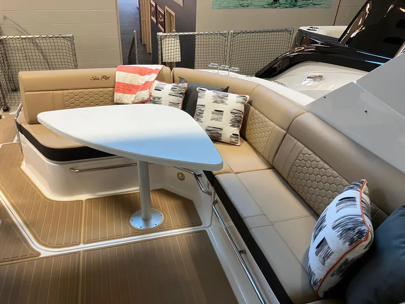 Slide: The Image of 2025 Sea Ray Sundancer 320 interior with cushioned seating and triangular table. - 10
