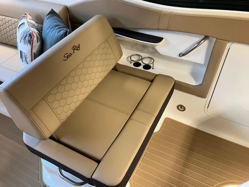 Slide: The Image of 2025 Sea Ray Sundancer 320 interior with tan seating and cup holders. - 11