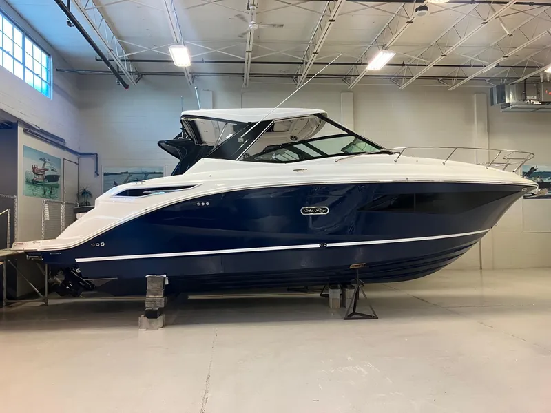 Slide: The Image of 2025 Sea Ray Sundancer 320 boat in indoor storage, showcasing sleek design and modern features. - 2