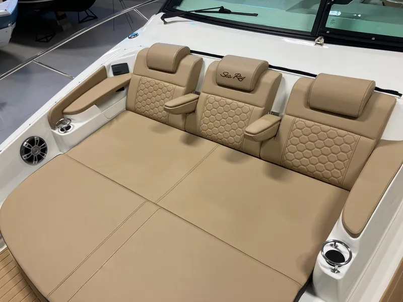 Slide: The Image of Luxurious seating on 2025 Sea Ray Sundancer 320 boat, featuring beige upholstery and cup holders. - 21