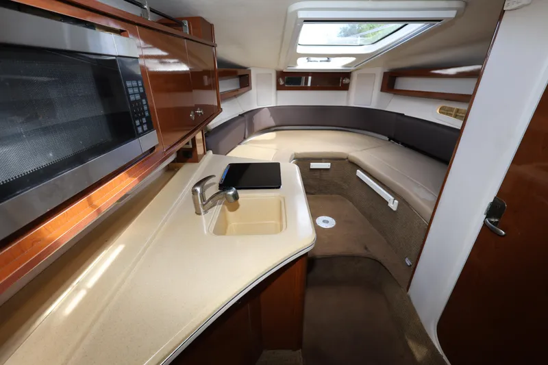 Slide: The Image of 2014 Sea Ray 280 Sundancer interior with kitchenette and seating area. - 17