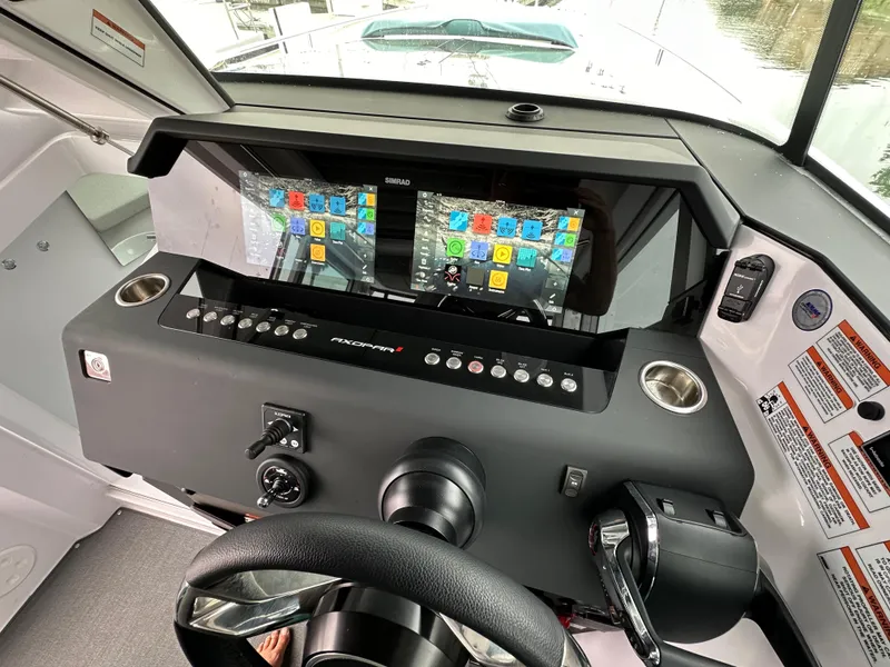 Slide: The Image of 2023 Axopar 37 XC Crosscabin dashboard with dual navigation screens and control panel. - 1