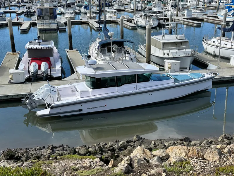 Slide: The Image of 2023 Axopar 37 XC Crosscabin docked in a marina with other boats. - 11