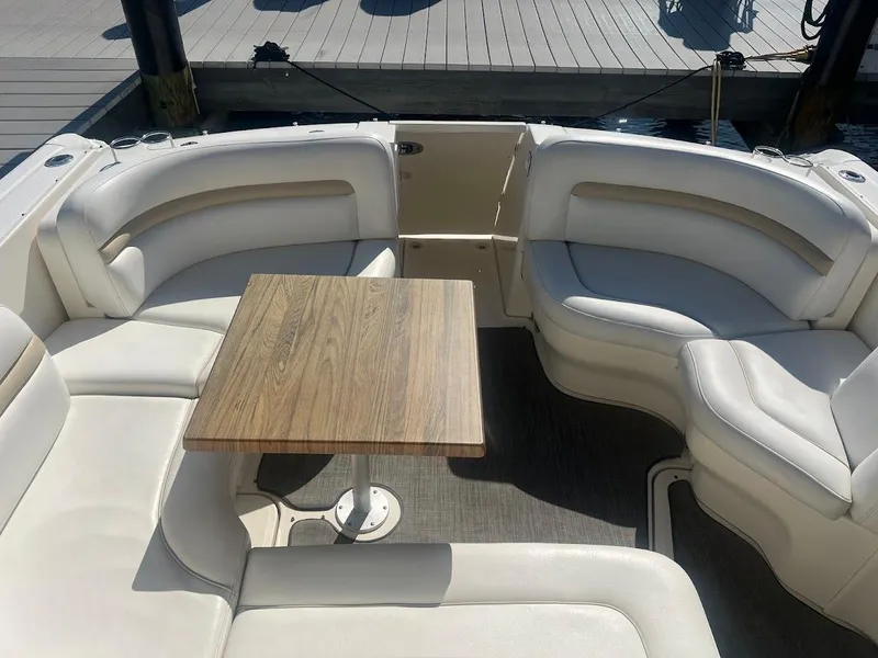 Slide: The Image of 2008 Sea Ray 38 Sundancer boat interior with white seating and wooden table. - 16