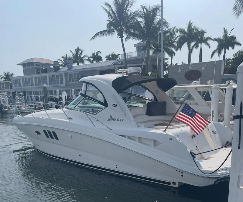 Slide: The Image of 2008 Sea Ray 38 Sundancer yacht docked near palm trees and waterfront buildings. - 2