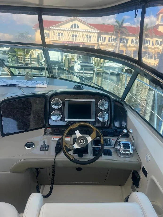 Slide: The Image of 2008 Sea Ray 38 Sundancer helm with modern controls and waterfront view. - 21