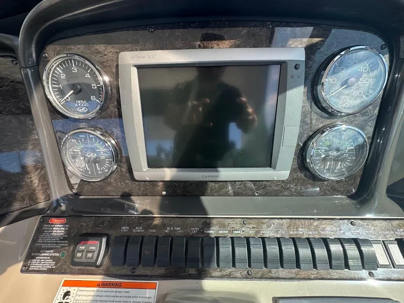 Slide: The Image of Dashboard of a 2008 Sea Ray 38 Sundancer with gauges and a central display. - 22