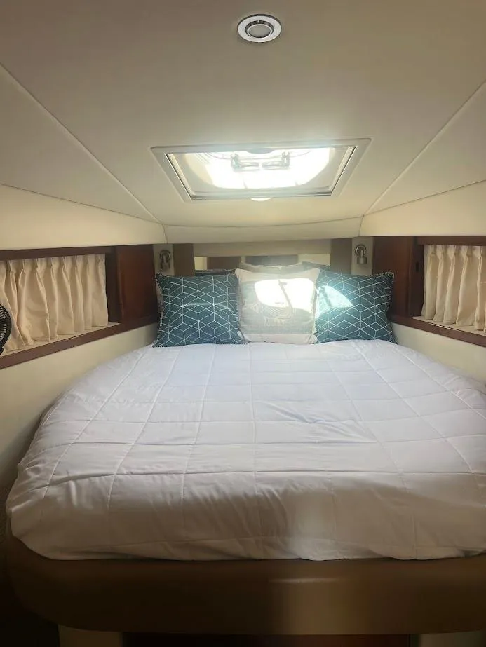Slide: The Image of 2008 Sea Ray 38 Sundancer cabin with bed, skylight, and decorative pillows. - 34