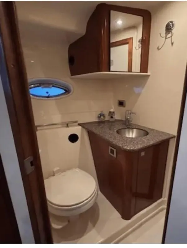 Slide: The Image of 2008 Sea Ray 38 Sundancer bathroom with sink, toilet, and porthole window. - 36