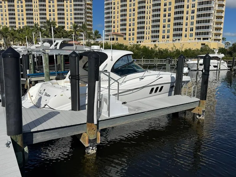 Slide: The Image of 2008 Sea Ray 38 Sundancer docked at marina with tall buildings in background. - 5