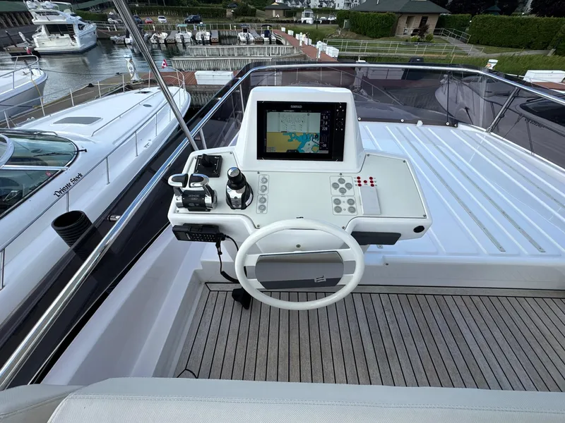 Slide: The Image of Helm station of 2022 Ferretti Yachts 550 with navigation controls and display. - 29