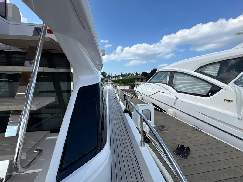 Slide: The Image of 2022 Ferretti Yachts 550 docked, showcasing sleek design and modern features under a clear sky. - 32